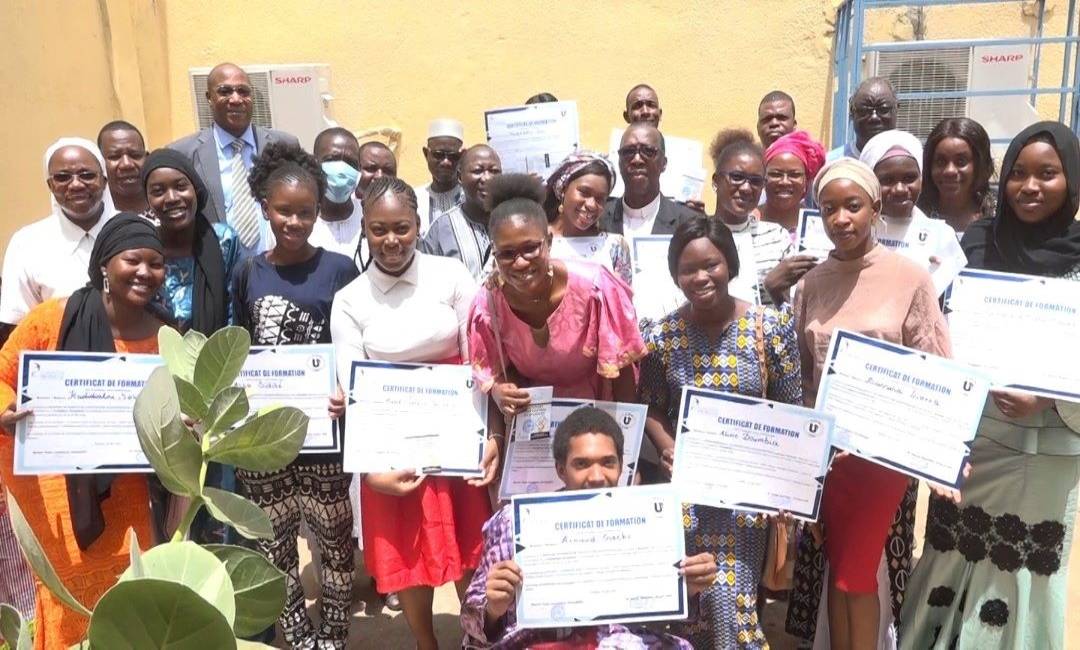Young journalists from UCOA-UUBa proudly hold up their training certificates. 