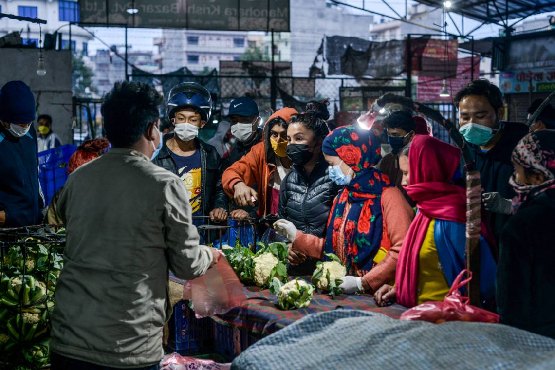 Des personnes portant un masque comme mesure préventive contre la COVID-19 sur un marché local à Katmandou, au Népal, le 25 mars 2020.