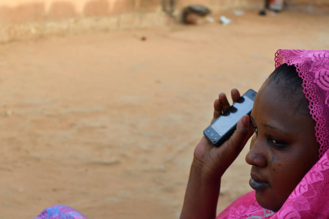 A women listening to Studio Kalangou on her smartphone in Niamey, Niger.