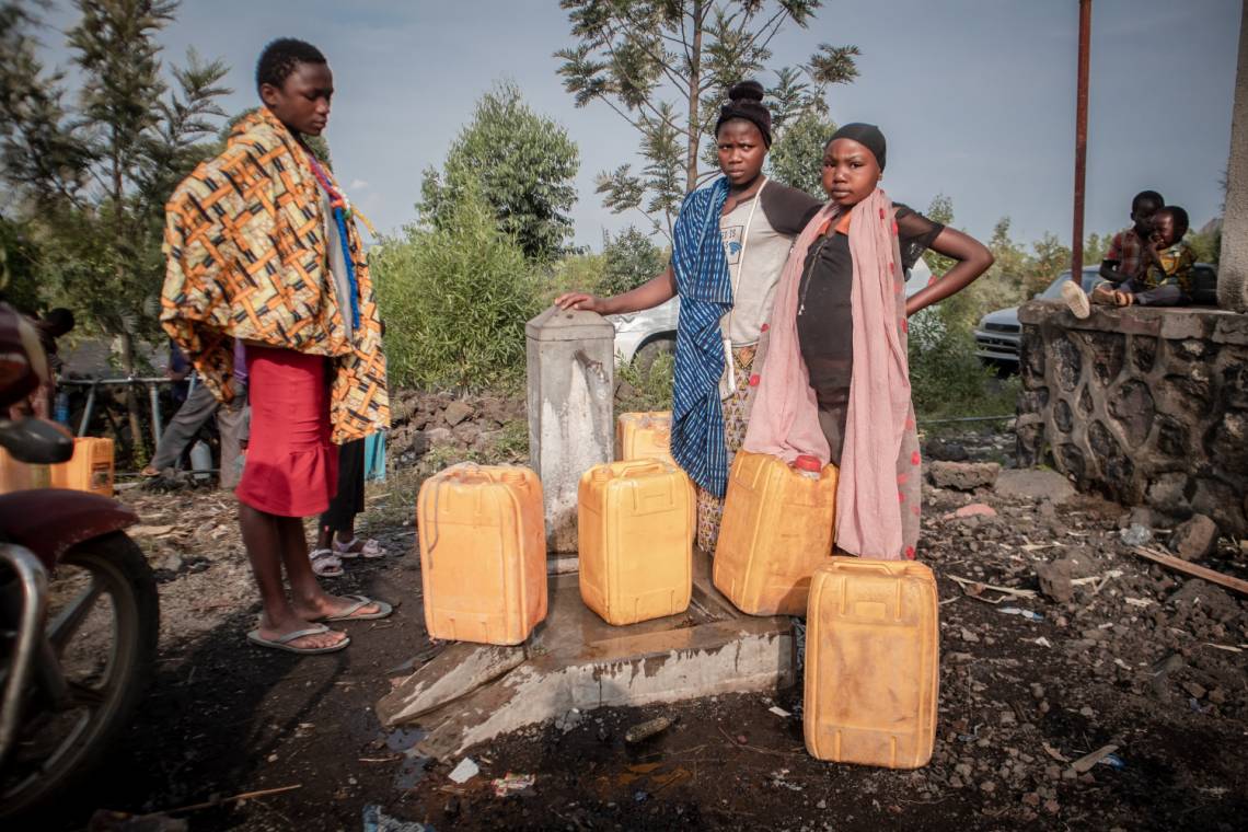 Des enfants font la queue pour obtenir de l&#039;eau distribuée par le gouvernement aux résidents déplacés par l&#039;éruption volcanique du Mont Nyiragongo à Sake, à 25 km au nord-ouest de Goma, le 29 mai 2021.