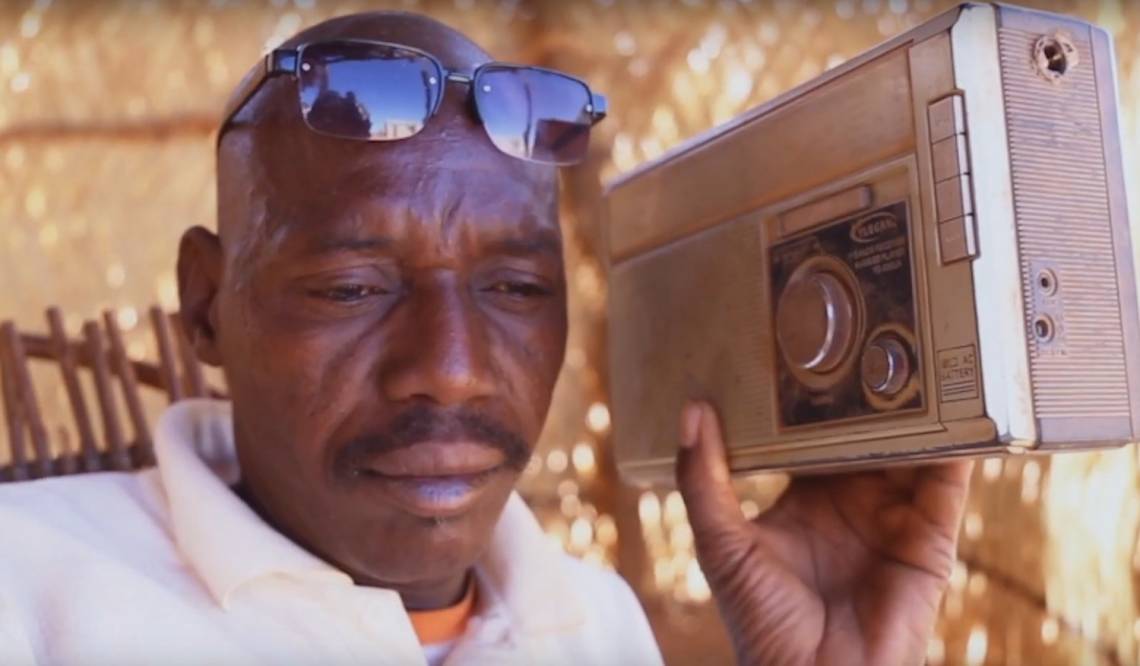 The representative of an IDP camp listening to the radio. 