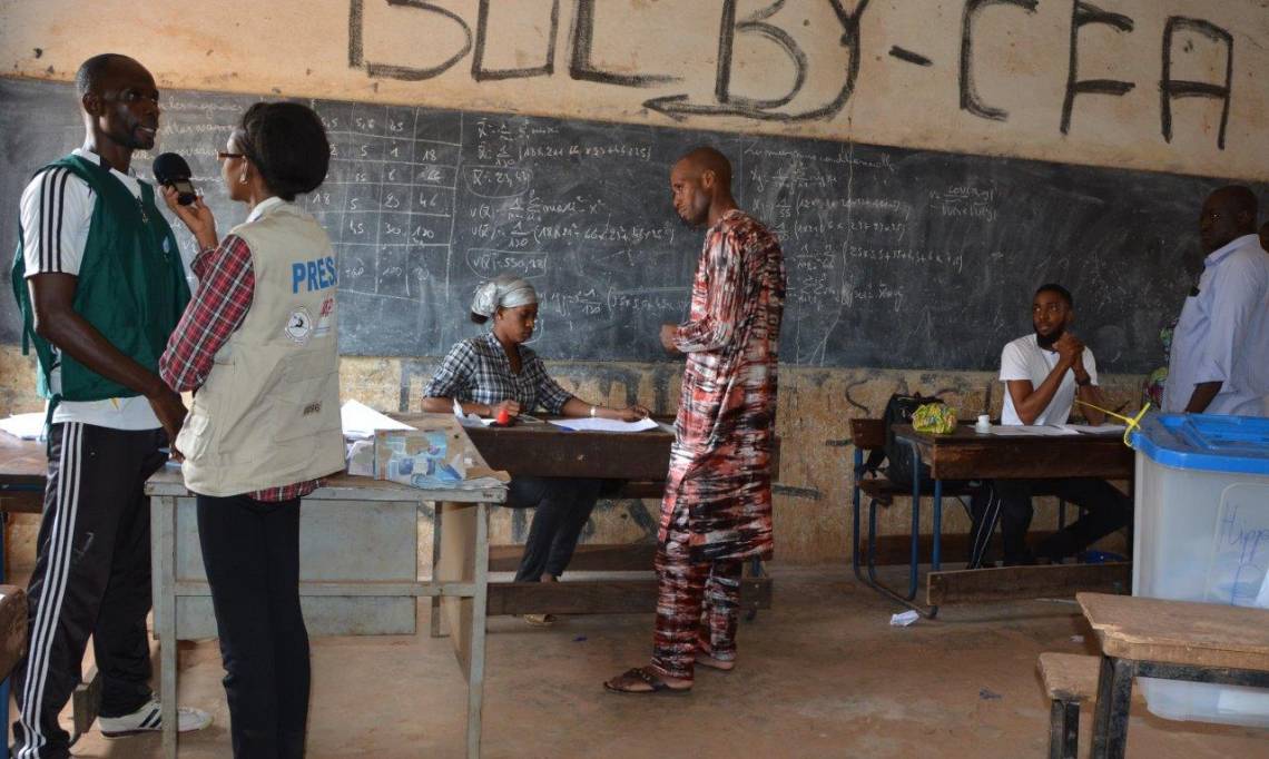 A journalist from Studio Tamani reporting on a polling station in Bamako during the first round of the presidential election in Mali on July 29, 2018.