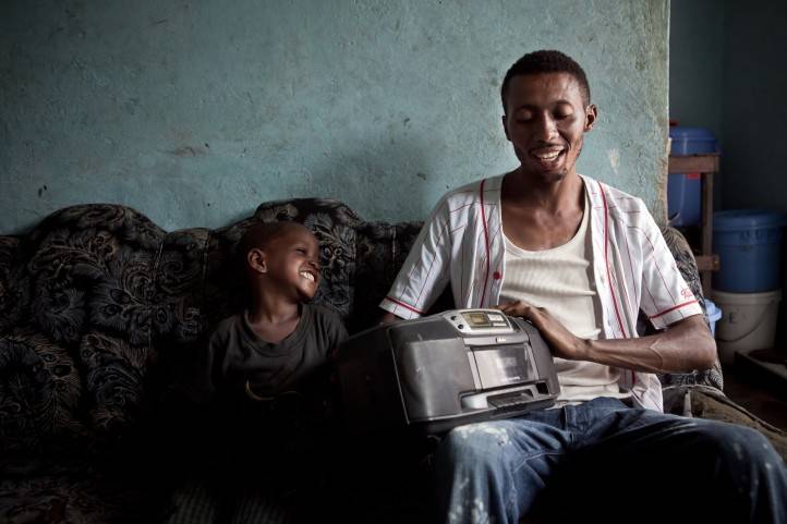A father and his son listen to the radio in Kinshasa, DRC.