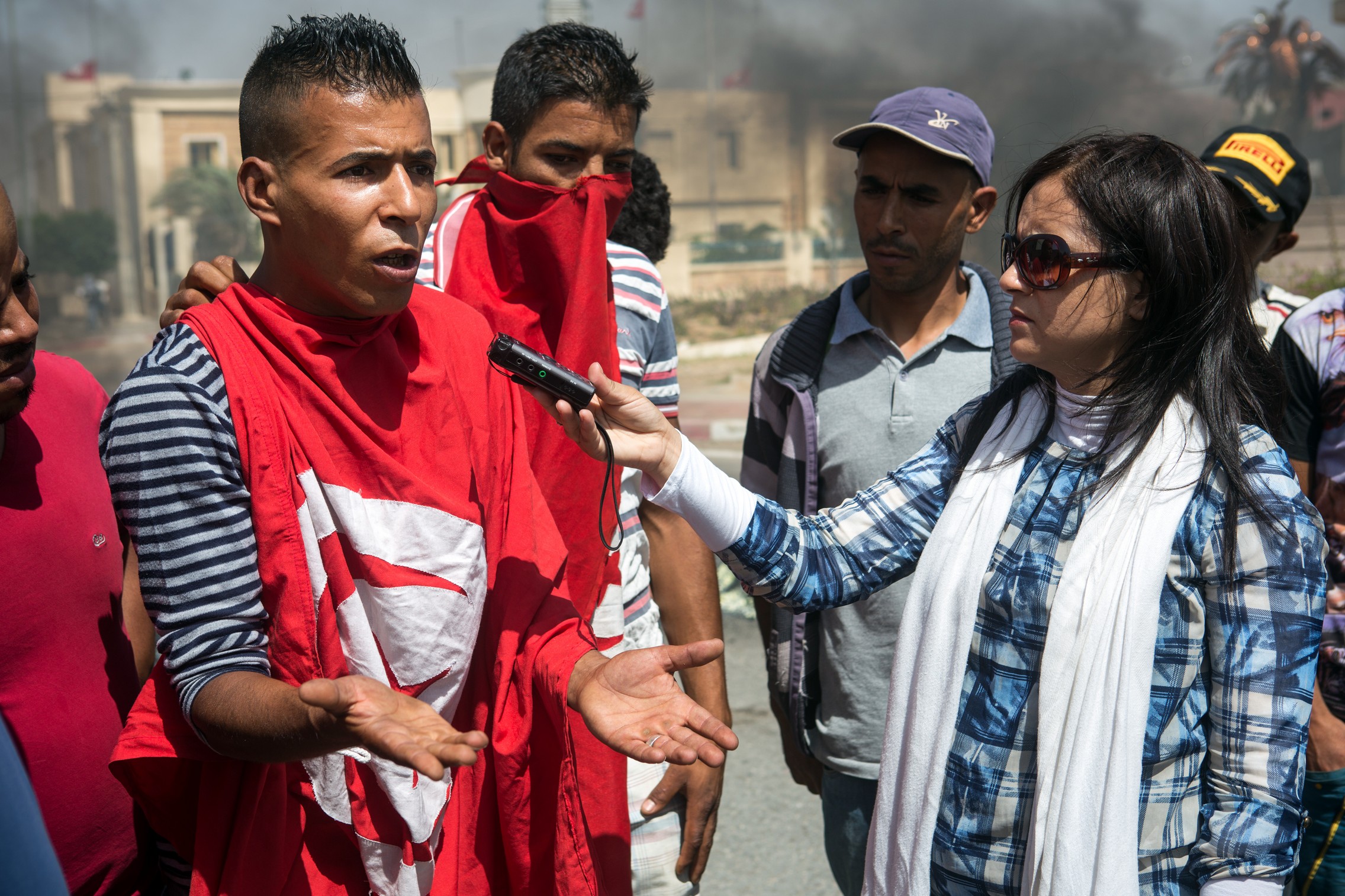 Une correspondante de la radio régionale tunisienne interviewe des manifestants à Gafsa, à 350 km au sud de Tunis, le 16 juin 2015. © Fondation Hirondelle / Gwenn Dubourthoumieu