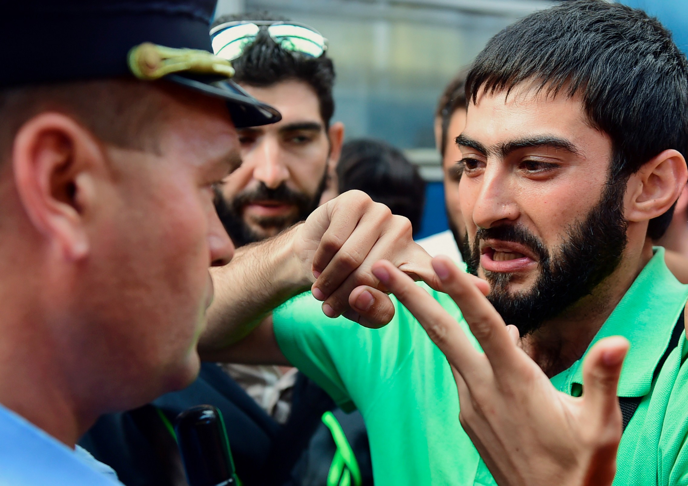 Un migrant discute avec un policier à la gare de Budapest le 1er septembre 2015.  © AFP PHOTO / ATTILA KISBENEDEK
