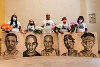 Relatives of five youngsters murdered during mass violences in Colombia, pose with their portraits. House of Memories of Conflict and  Reconciliation, Cali, October 2020.