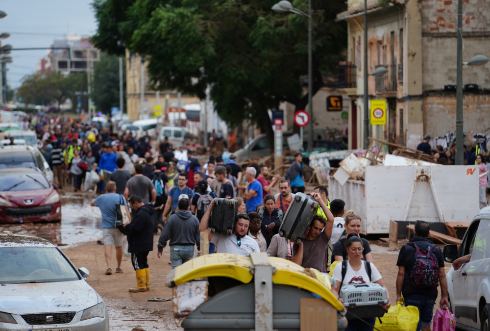 Residents walk in the street while transporting belongings following deadly flash floods in La Torre, south of Valencia, eastern Spain, on October 31, 2024. Rescuers raced on October 31, 2024 to find survivors and victims of once-in-a-generation floods in Spain that killed at least 95 people and left towns submerged in a muddy deluge with overturned cars scattered in the streets. About 1,000 troops joined police and firefighters in the grim search for bodies in the Valencia region as Spain started three days of mourning. Up to a year's rain fell in a few hours on the eastern city of Valencia and surrounding region on October 29 sending torrents of water and mud through towns and cities. (Photo by Manaure QUINTERO / AFP)