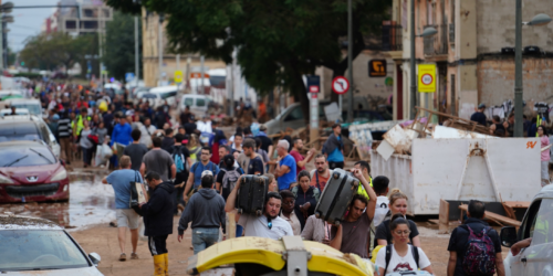 Residents walk in the street while transporting belongings following deadly flash floods in La Torre, south of Valencia, eastern Spain, on October 31, 2024. Rescuers raced on October 31, 2024 to find survivors and victims of once-in-a-generation floods in Spain that killed at least 95 people and left towns submerged in a muddy deluge with overturned cars scattered in the streets. About 1,000 troops joined police and firefighters in the grim search for bodies in the Valencia region as Spain started three days of mourning. Up to a year's rain fell in a few hours on the eastern city of Valencia and surrounding region on October 29 sending torrents of water and mud through towns and cities. (Photo by Manaure QUINTERO / AFP)
